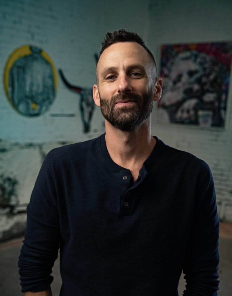 Ari Hauben standing in front of his artwork