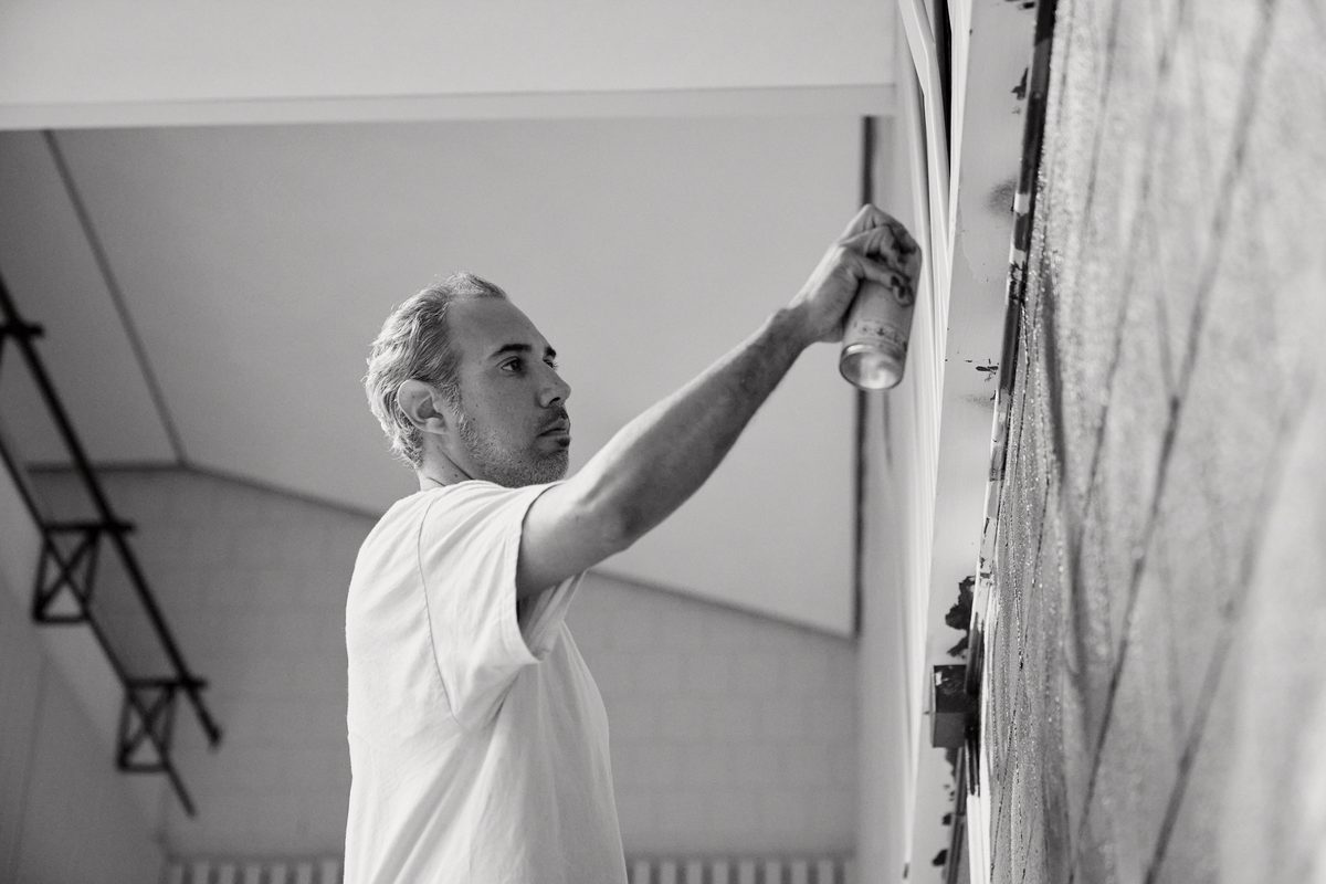 Felipe Ortiz spray painting a mural in his studio