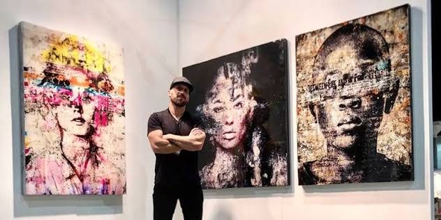 Markus Sebastiano standing in front of three of his mixed media portraits
